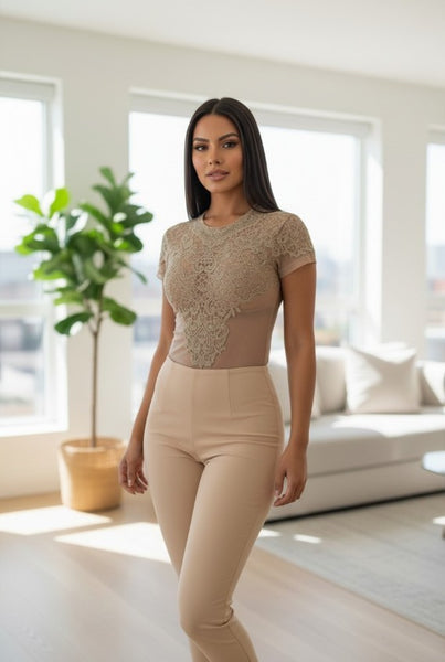 Woman wearing a Beige top with lace details and high-waisted pants in a bright room.