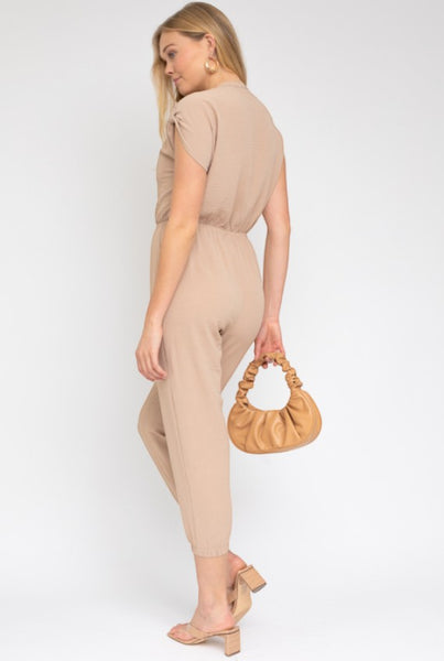 Collab Boutique beige dolman short sleeve button up jumpsuit made of 100% polyester with elastic waist and cuffed ankles.