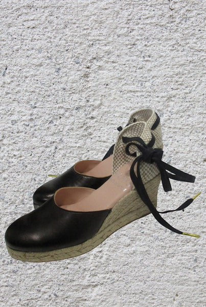 Collab Boutique black leather espadrille wedge sandals with jute sole and black laces with gold tips.