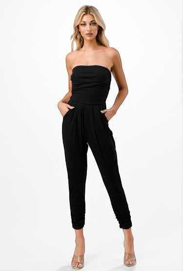 Collab Boutique black strapless ruched bodice jumpsuit with tapered legs and side pockets, made of polyester and spandex.