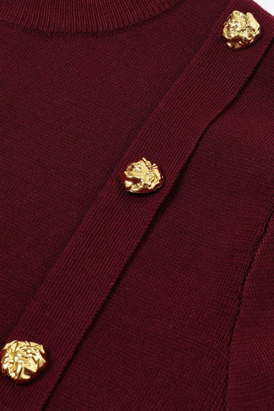 Collab Boutique burgundy knit crew neck pullover top with gold buttons and white pleats detail. Cotton-viscose blend.