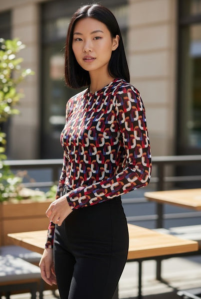 Collab Boutique long sleeve crew neck bodysuit with a colorful geometric print in red, blue, white, and orange on a black mesh fabric.