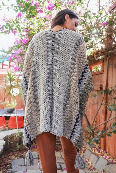 Collab Boutique multi-color crochet poncho with geometric patterns and tassels. One size fits most.