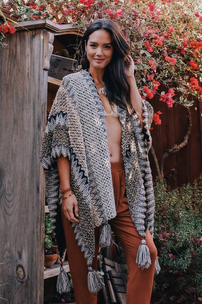 Collab Boutique multi-color crochet poncho with tassels and geometric patterns. One size fits most.