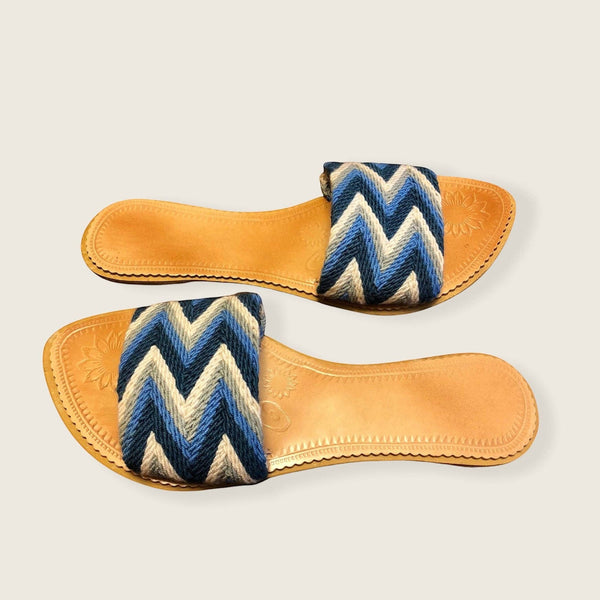Collab Boutique colorful handwoven slide sandals with blue, grey, and white zig-zag pattern straps and leather insoles.