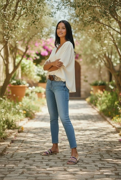 Collab Boutique ivory diamond patterned beaded belt with elastic and wooden buckle, worn by a model with jeans.