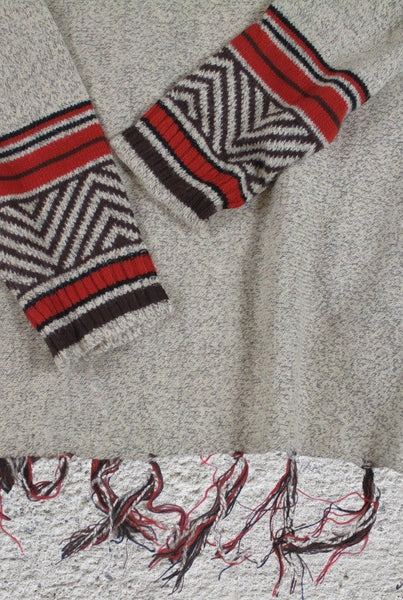 Collab Boutique tan, brown, auburn, black knit sweater with geometric pattern on cuffs and fringe hem.