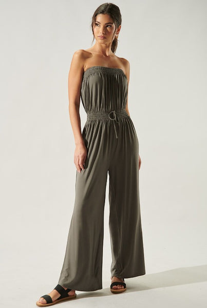 Collab Boutique olive green strapless wide-leg jumpsuit with smocked bodice and drawstring waist, worn by a model.