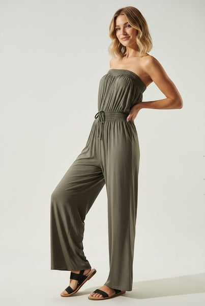 Collab Boutique olive green strapless wide-leg jumpsuit with smocked bodice and drawstring waist, worn by a model.