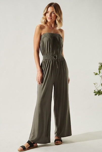 Collab Boutique olive green strapless wide-leg jumpsuit with smocked bodice and drawstring waist, worn by a model.
