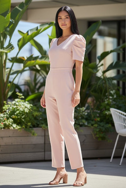 Collab Boutique pale pink polyester-elastane jumpsuit with puffed short sleeves, V-neck, and wide legs. Model wears a size S.