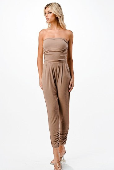 Collab Boutique taupe strapless ruched bodice jumpsuit with tapered legs and cinched ankles. Model is wearing a size S.