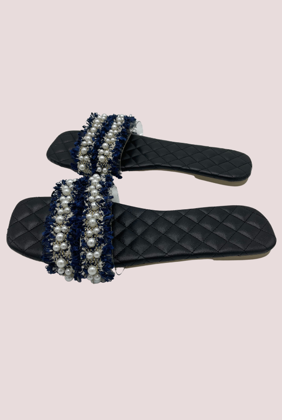 Navy blue ruffle & pearl slides with transparent strap on a black quilt detail insole.